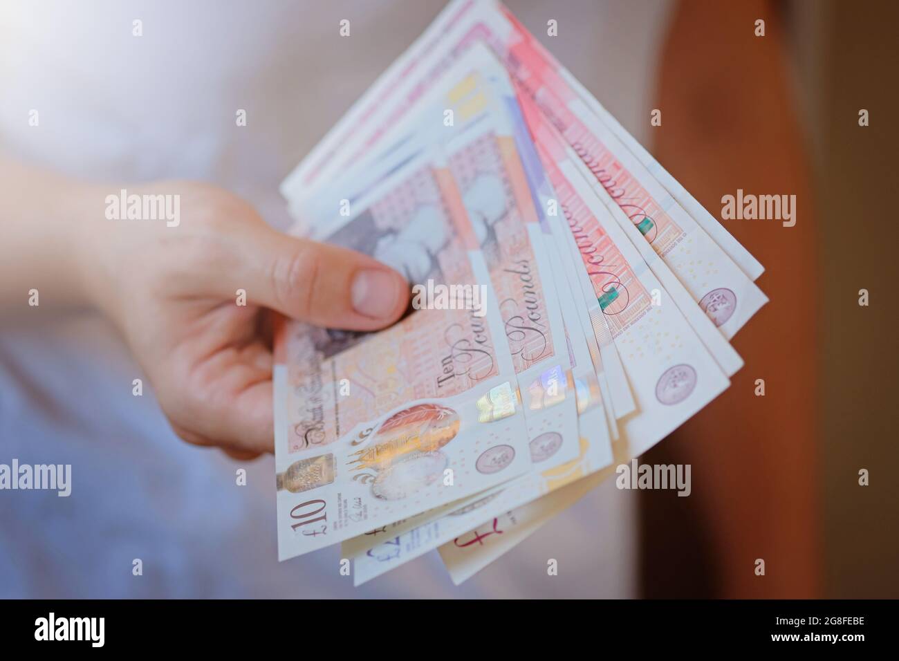 New Plastic Ten and twenty Pound note sterling in woman hands. Crisis and saving concept. British finance sistem  Stock Photo