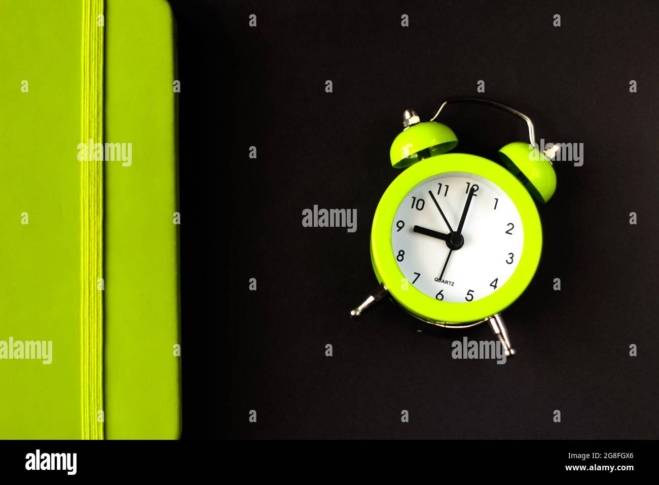 alarm clock morning wakeup time. Light green alarm clock on a black