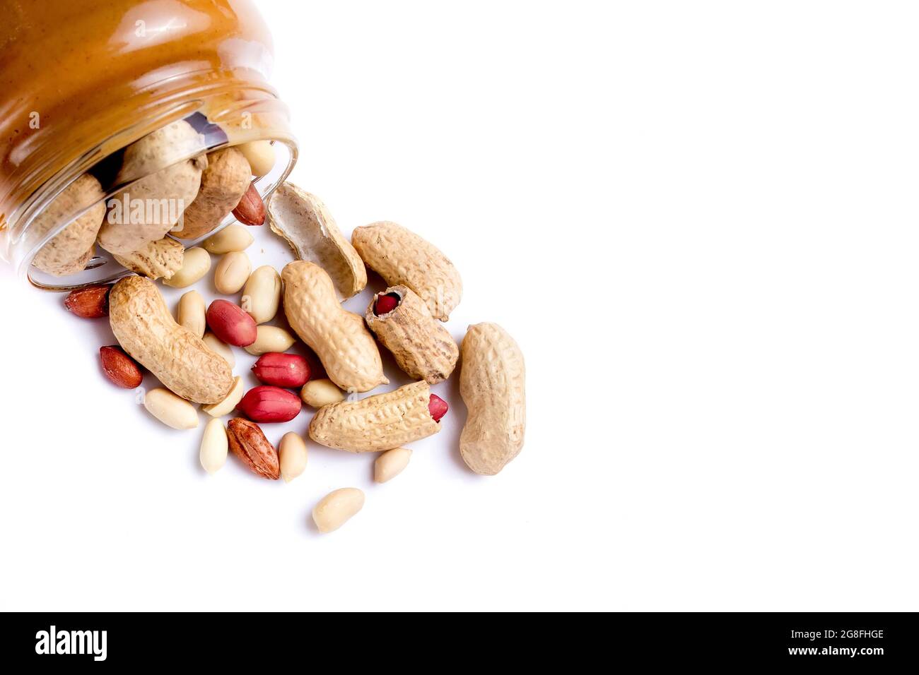 Peanut butter isolated and peanuts in the peel scattered on the white