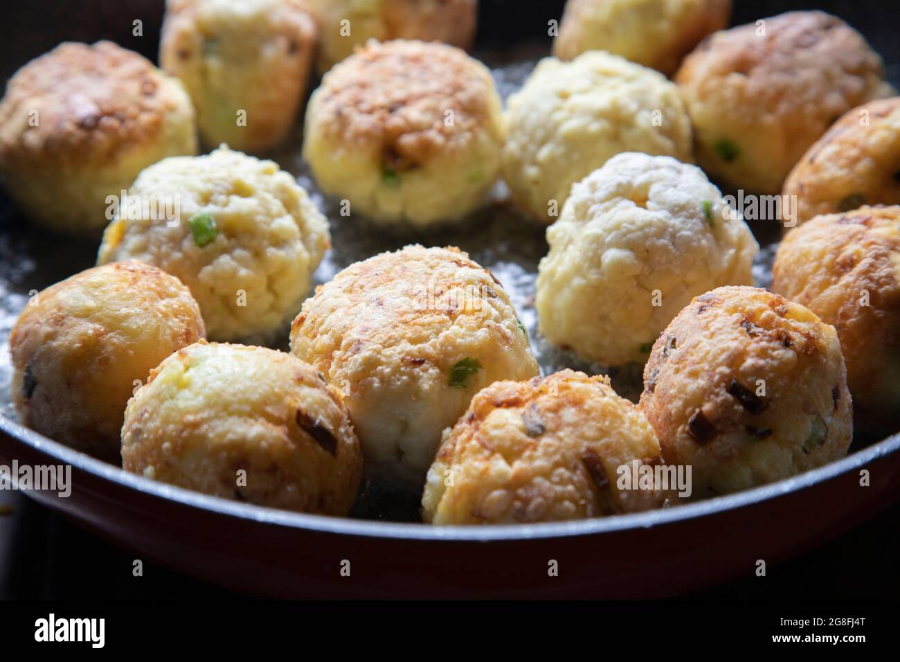 Golden brown breadfruit balls in a frying pan Stock Photo