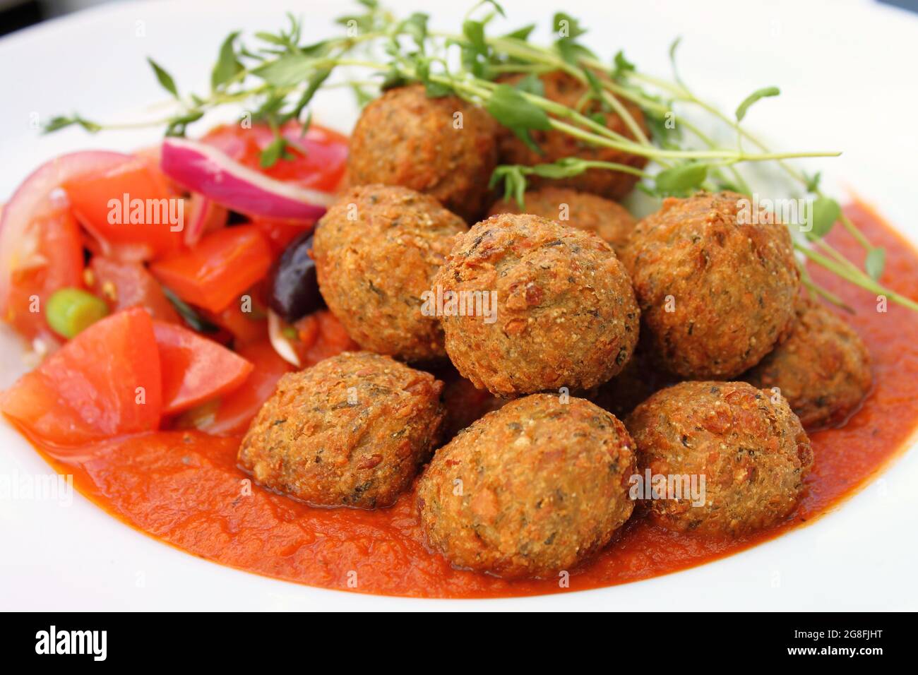 Vegetarian Falafel balls with tomato sauce and cucumber Riata salad, close-up. Stock Photo