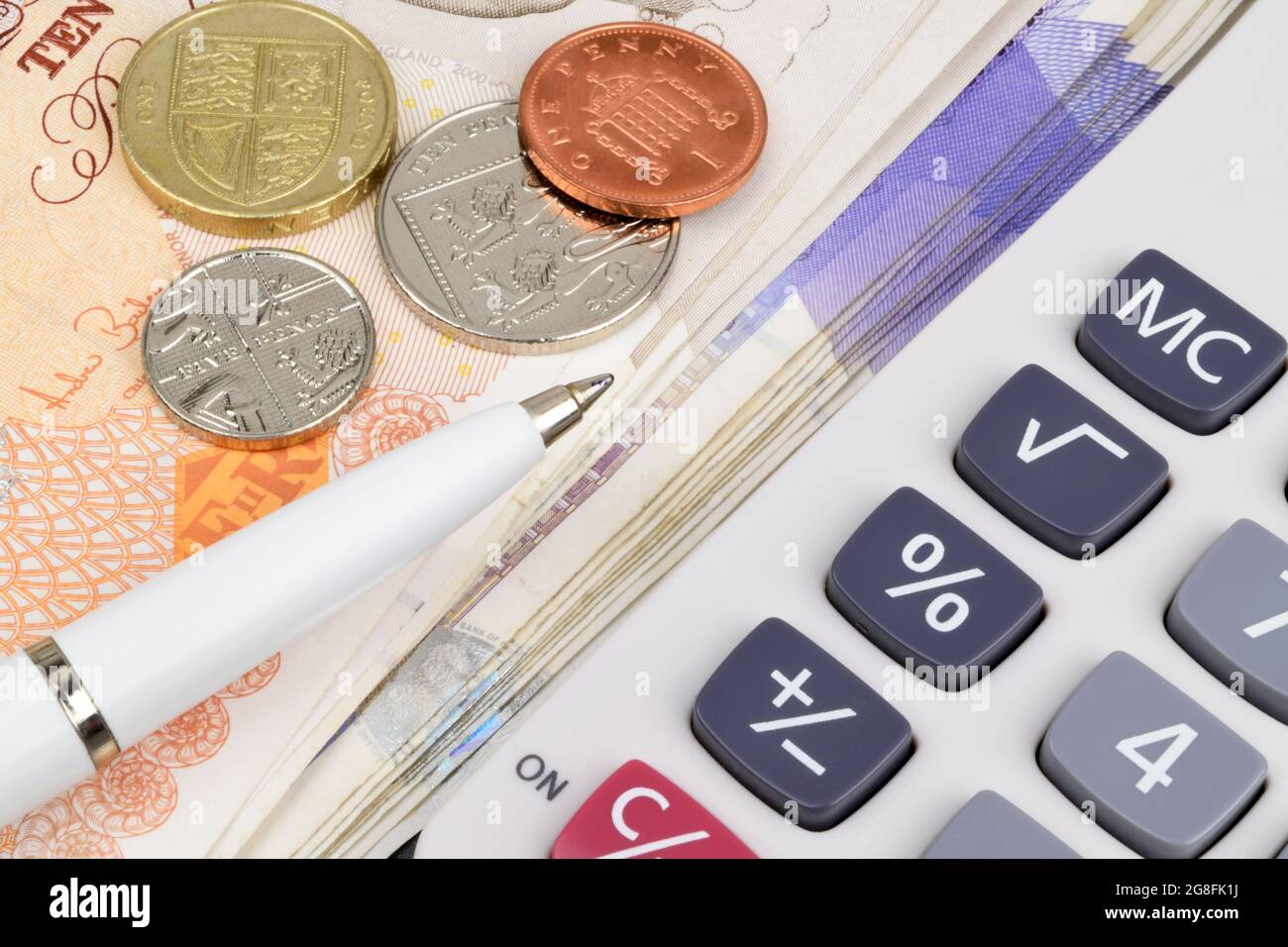 Sterling notes and coins with a pen and calculator. Stock Photo