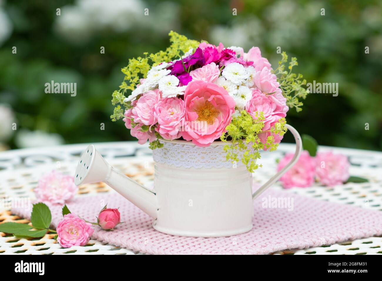 romantic bouquet of pink summer flowers in decorative watering can Stock Photo