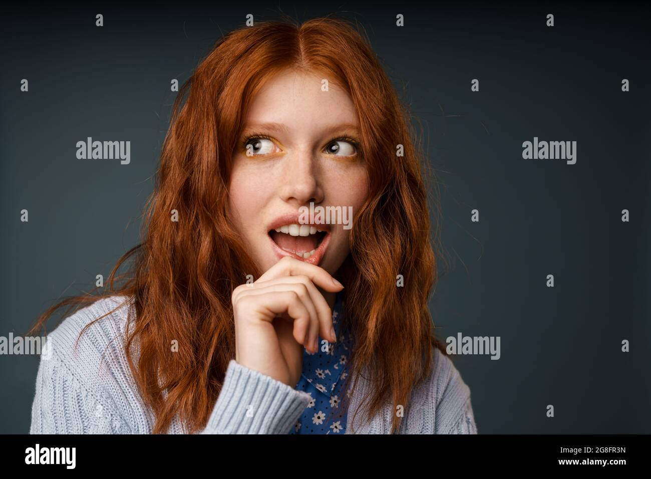 Young ginger surprised woman posing and looking aside isolated over ...