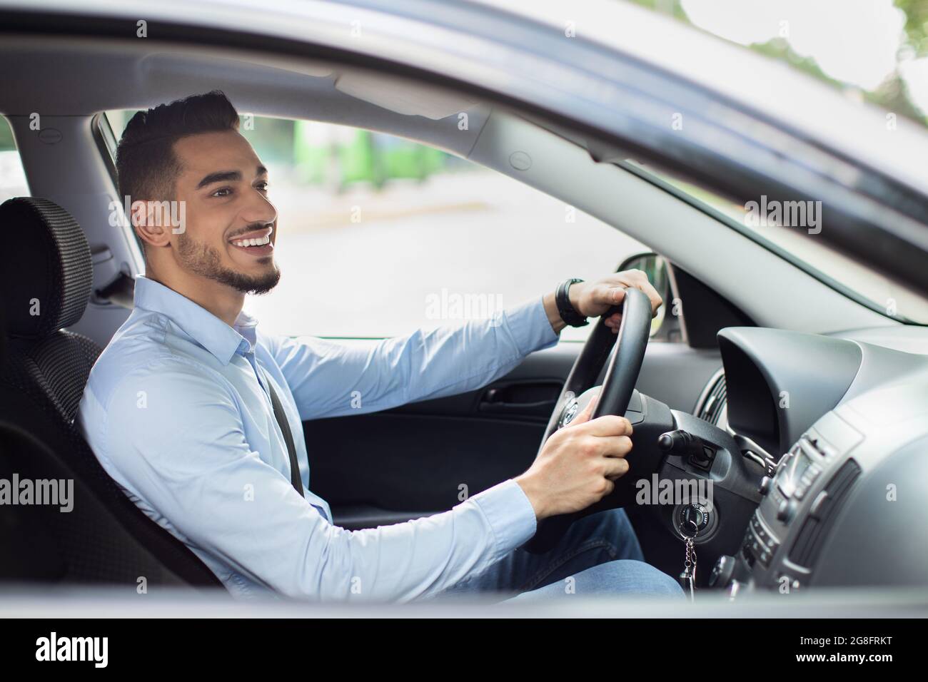 Excited arab guy going to office, driving his car Stock Photo
