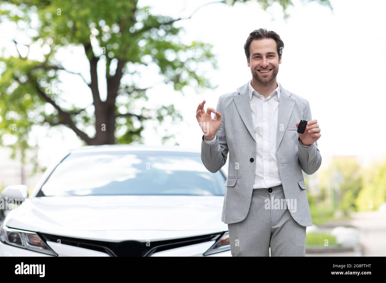 Great choice, salesman giving car key to customer, expert advice on renting and buying auto. Stock Photo