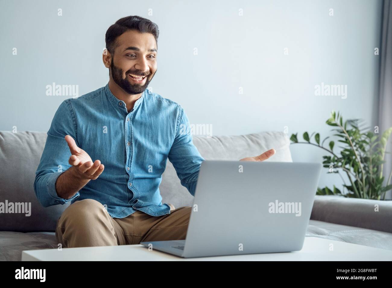 Happy toothy smiling indian man glad to see best friend making online video call Stock Photo