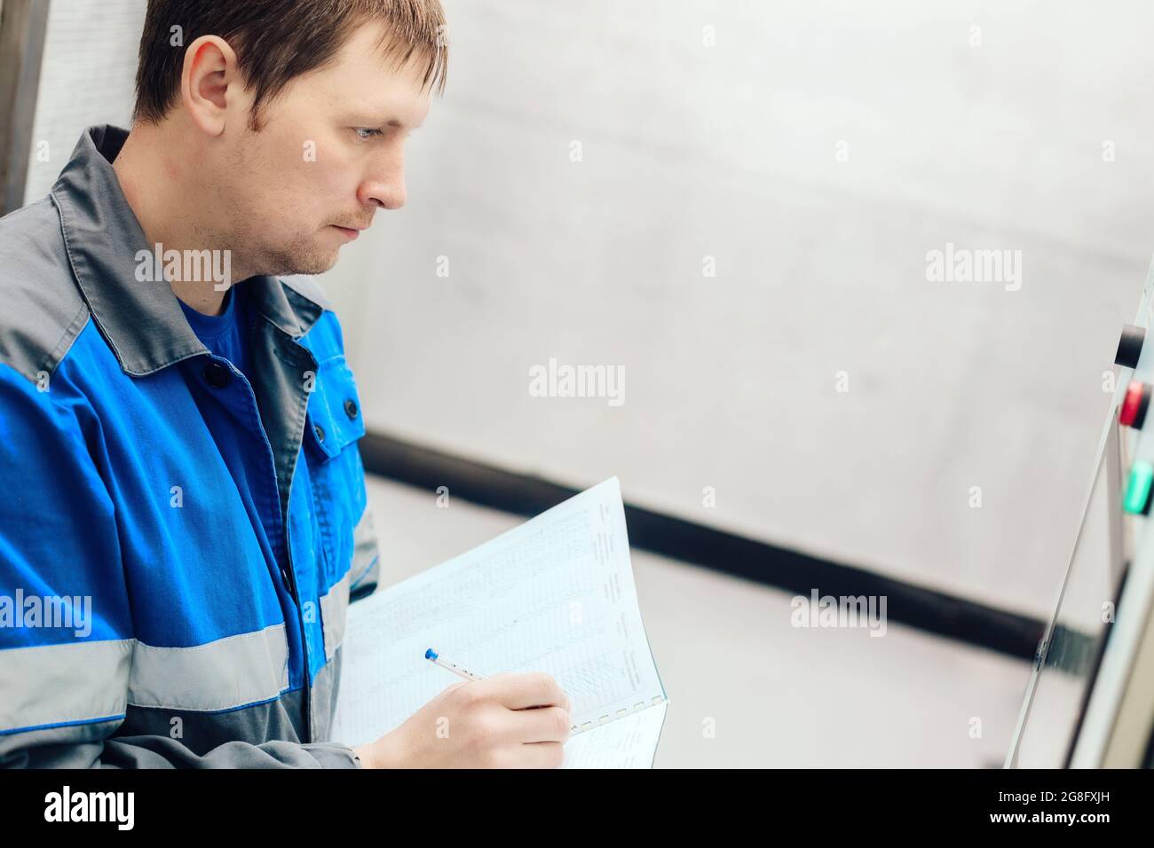 Engineer, worker registers readings of sensors and pressure gauges. Control of water supply and heating system. Checking the equipment before the start of the heating season Stock Photo