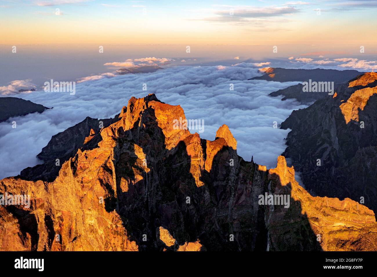 Clouds surrounding the rocky peak of Pico das Torres lit by sunset, Madeira island, Portugal, Atlantic, Europe Stock Photo