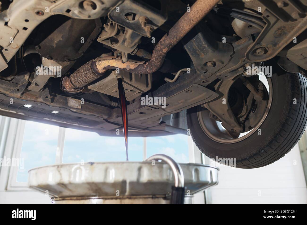 The process of draining used engine oil from the crankcase into the sump Stock Photo