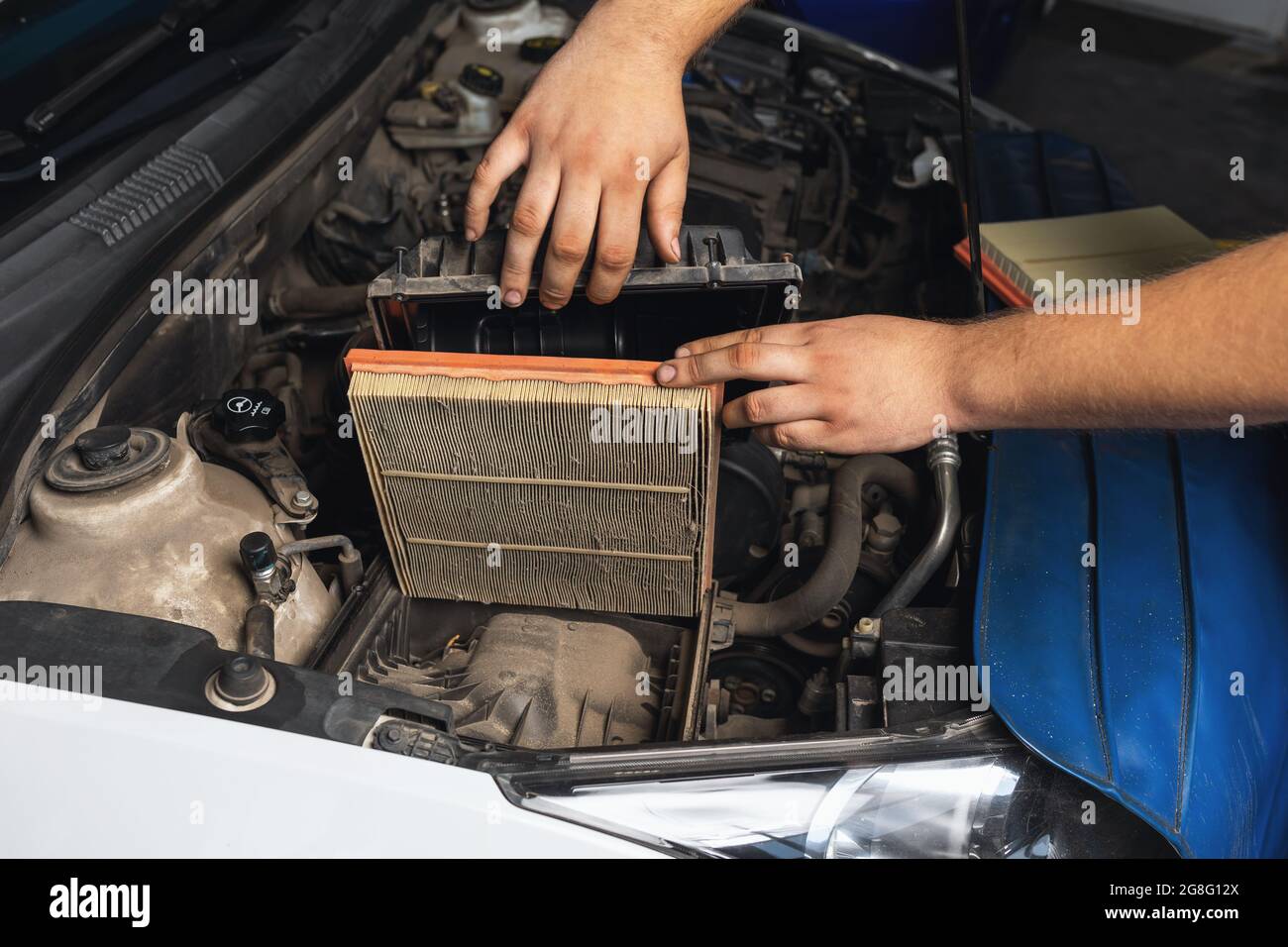 An auto mechanic shows an old engine air filter Stock Photo