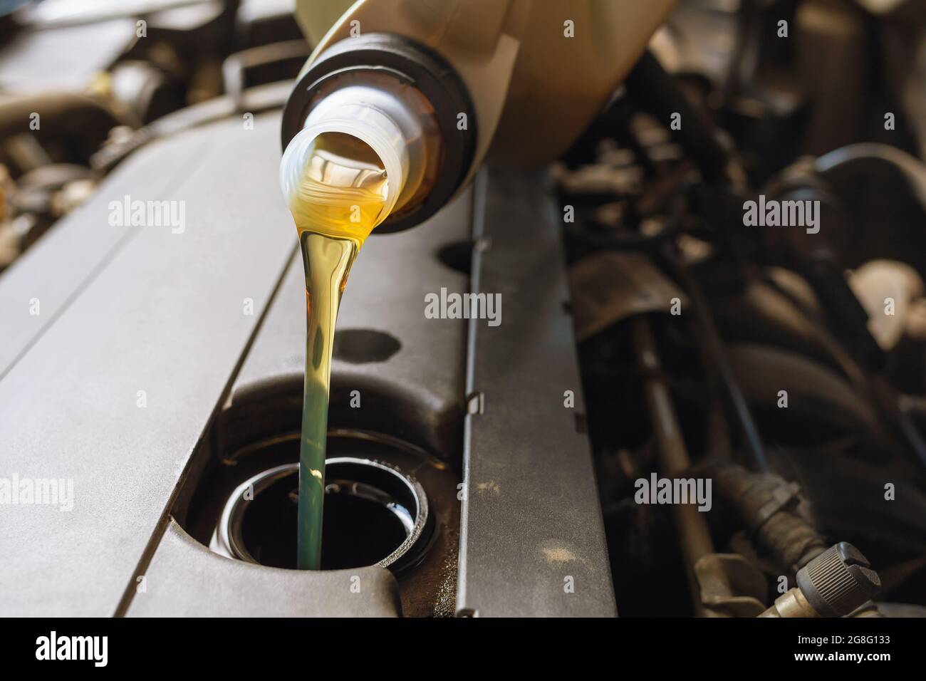 The process of pouring engine oil into the engine close-up Stock Photo ...