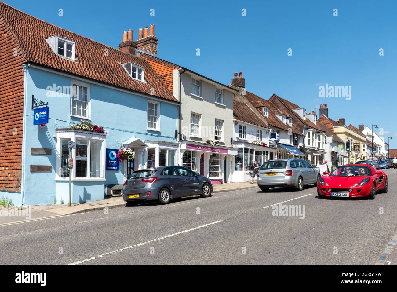 Colourful terraced houses and businesses in Alresford, a small Hampshire town, England, UK. View along West Street. Stock Photo