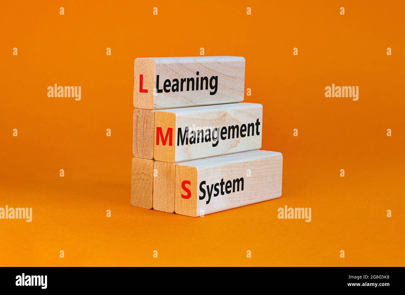 LMS, learning management system symbol. Wooden blocks with words 'LMS, learning management system'. Beautiful orange background, copy space. Business, Stock Photo