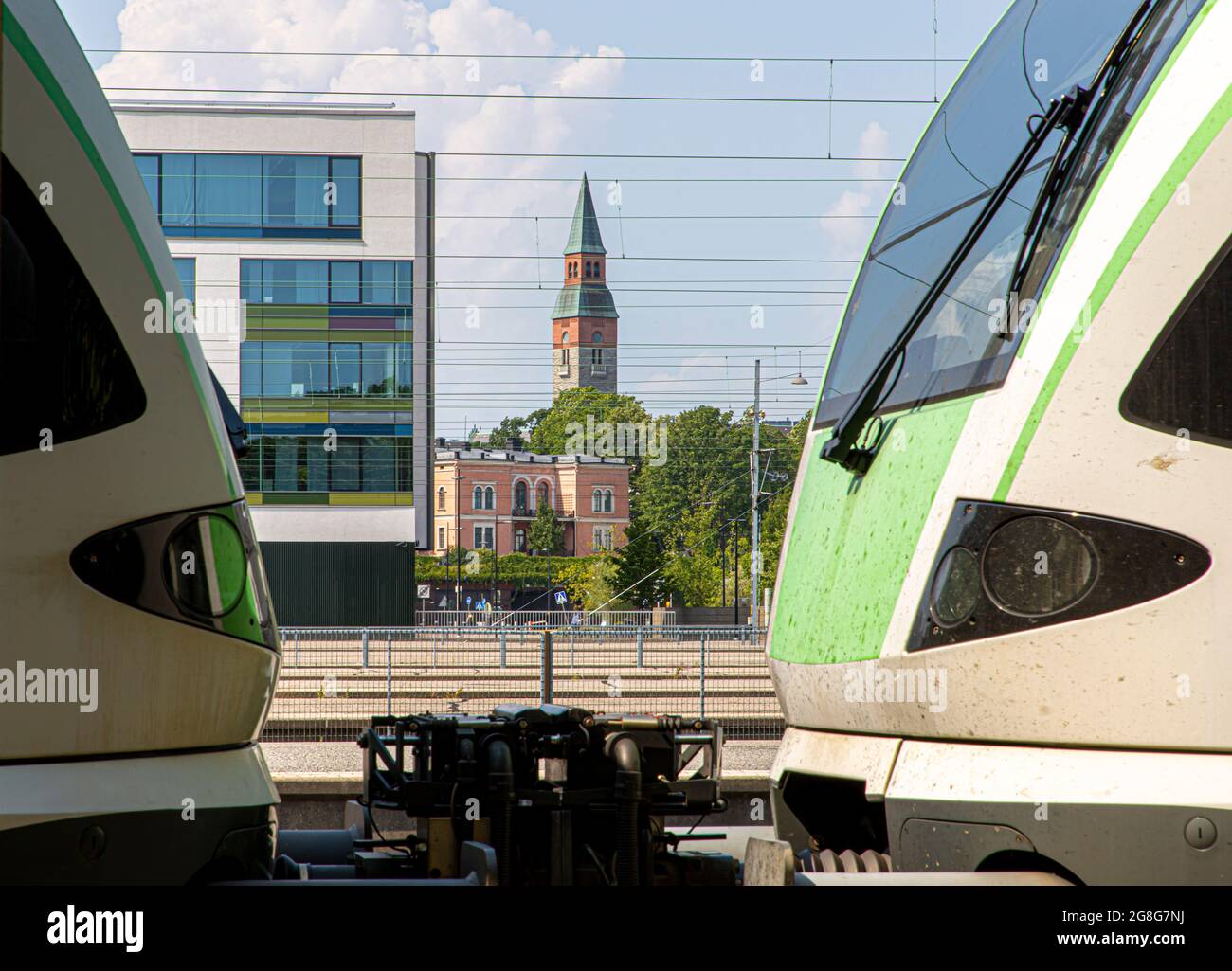 National Museum of Finland and Villa Hakasalmi against a foreground of a Stadler FLIRT trainset and a building at the Helsinki central railway station. Stock Photo