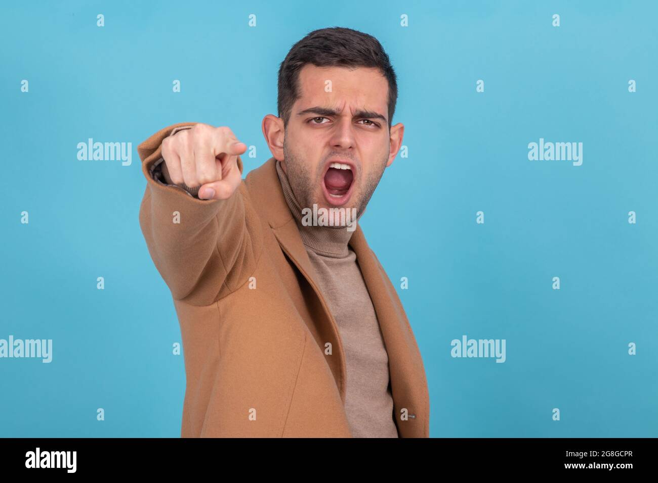 man screaming and pointing furious isolated on background Stock Photo