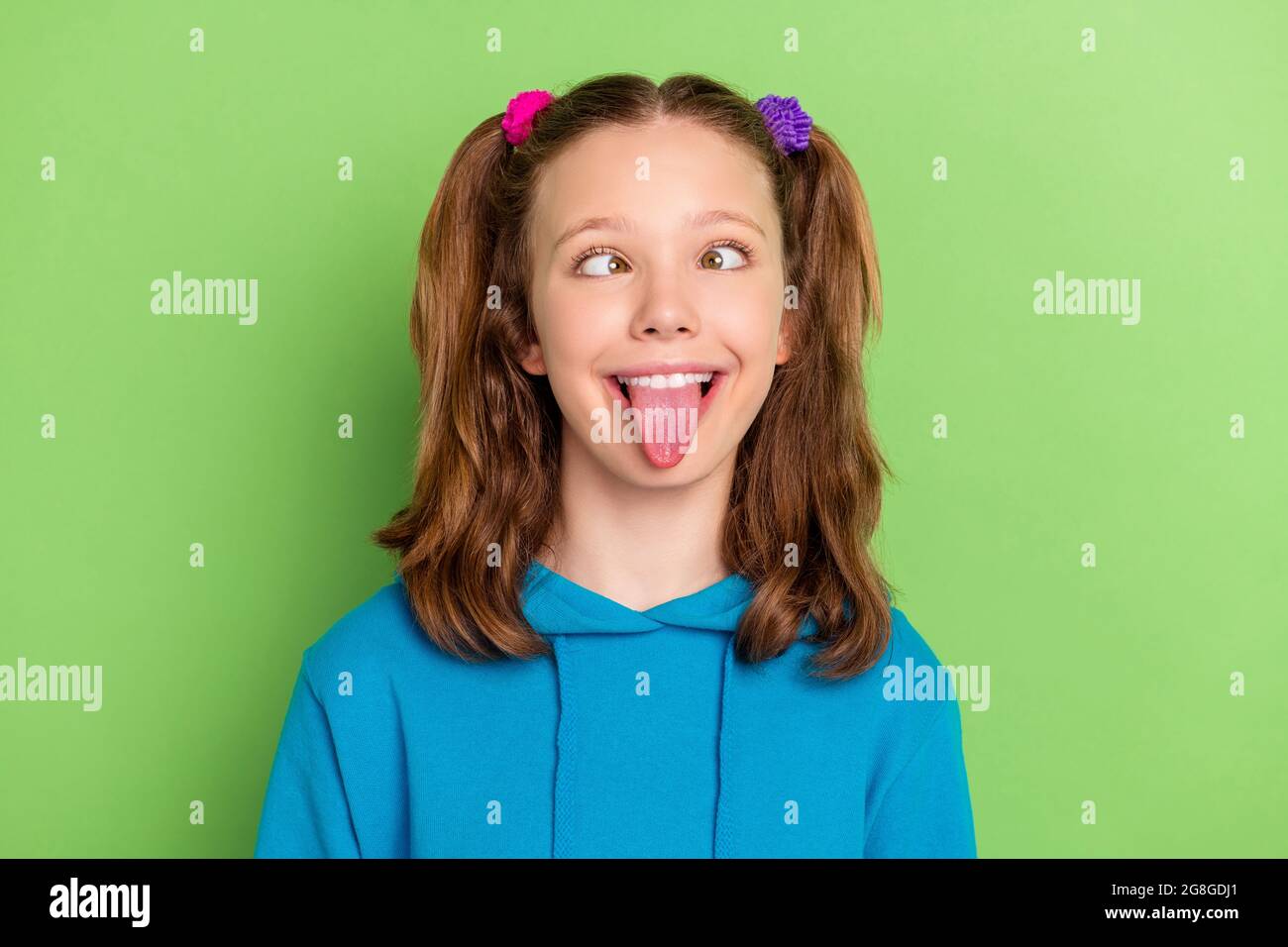 Photo of funky happy cheerful small girl make funny face good mood fooling  isolated on green color background Stock Photo - Alamy