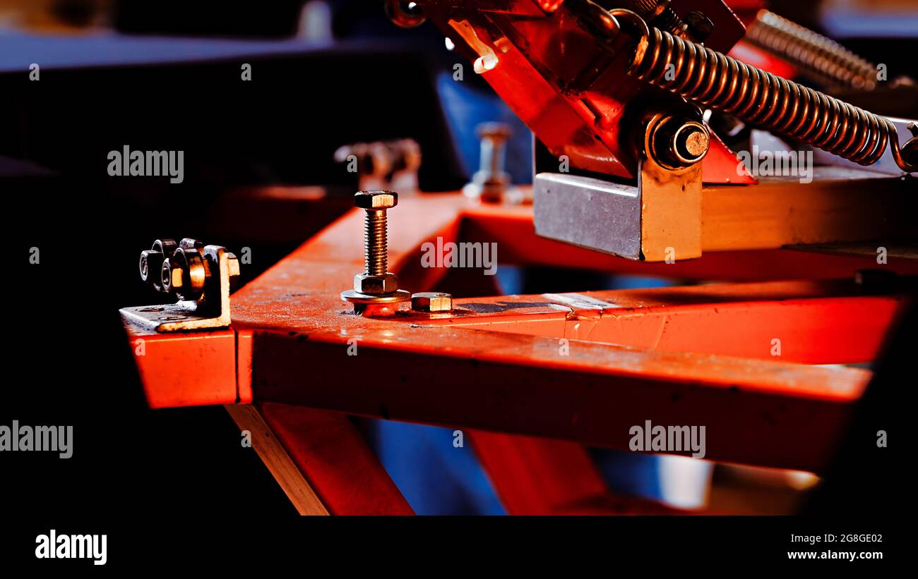 selective focus photo of the fragment of print screening apparatus. serigraphy production. printing images on t-shirts by silk screen method in a desi Stock Photo