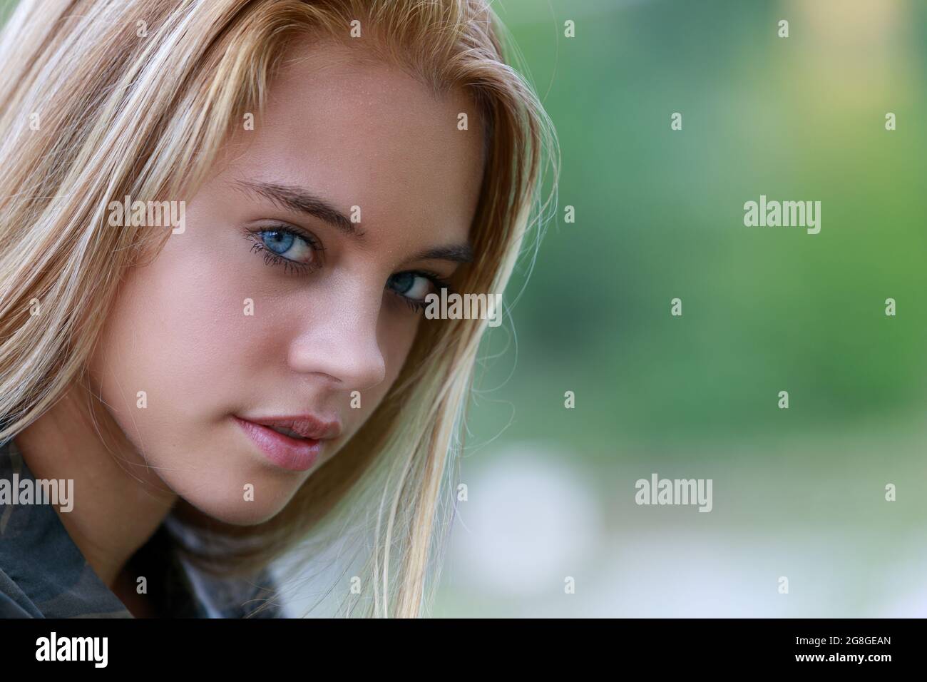 outdoor portrait of young blonde woman with intense gaze, natural ...