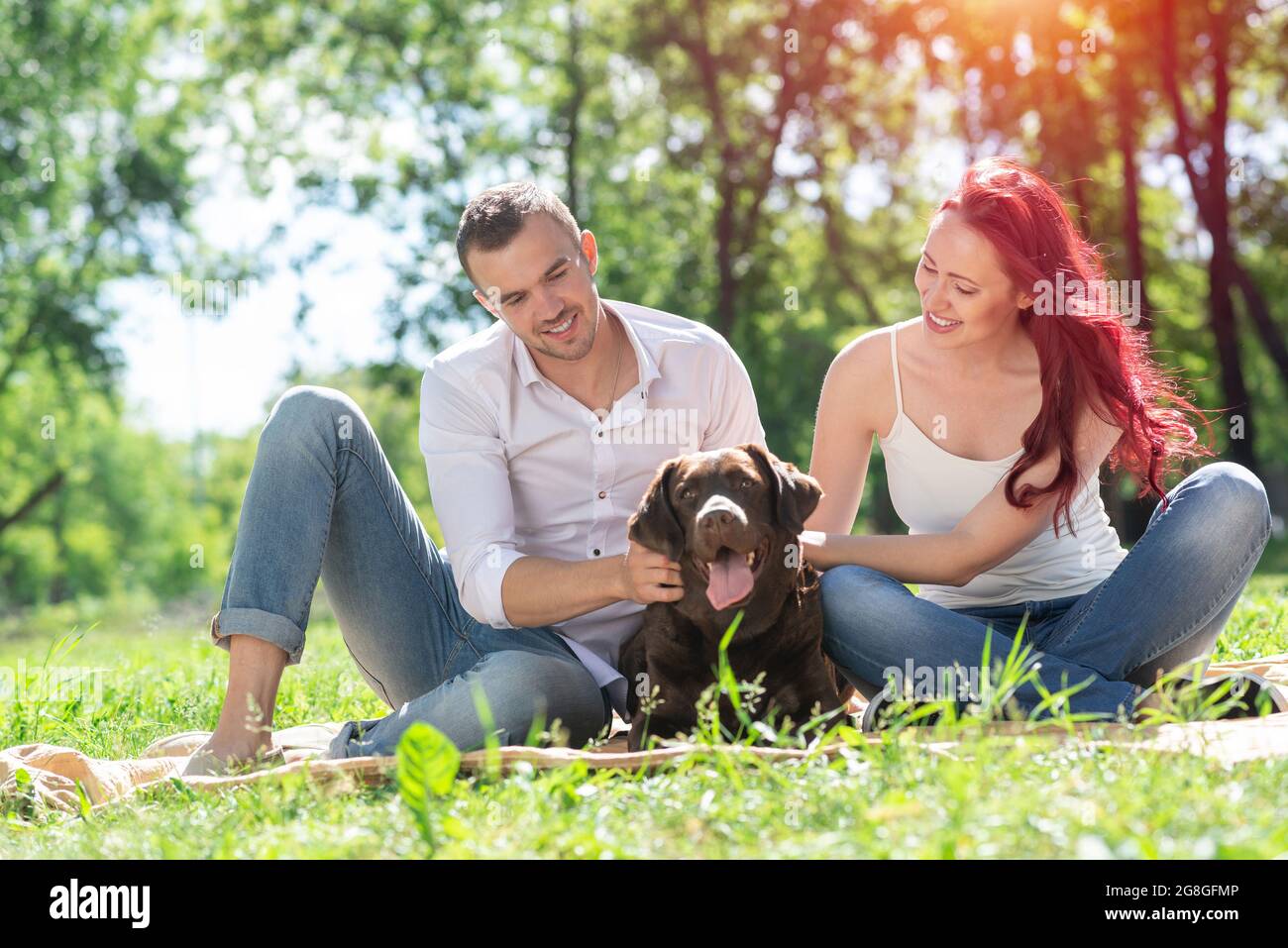 Couple with a dog in the park Stock Photo - Alamy