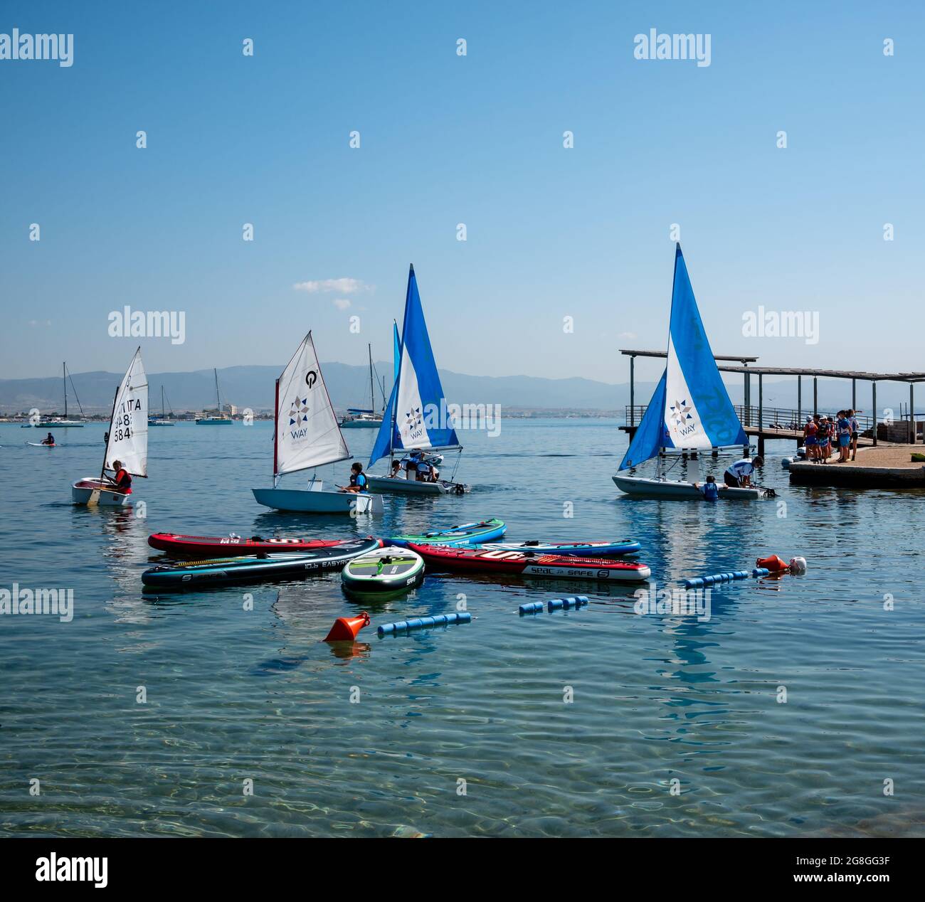 Group of children practice with small sailboats to compete in a regatta Stock Photo