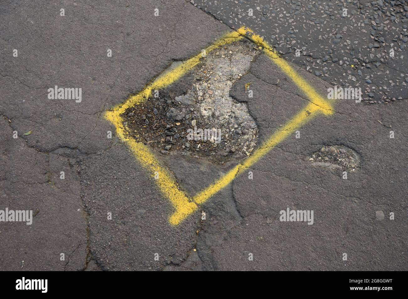 A pothole in the road, with marking in preparation for repair. Stock Photo