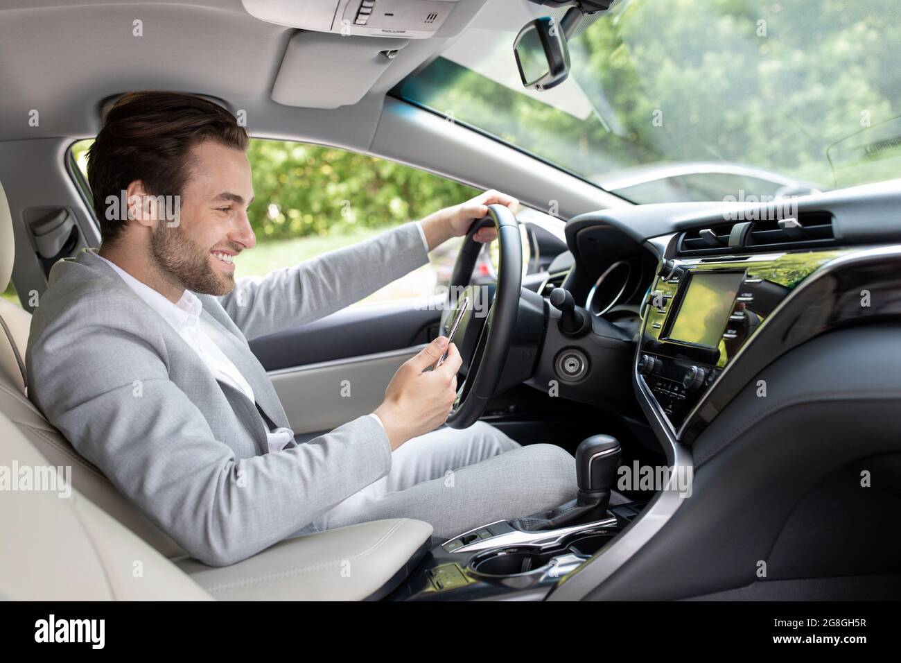 european man in suit is driving in city and looking at gps map Stock Photo