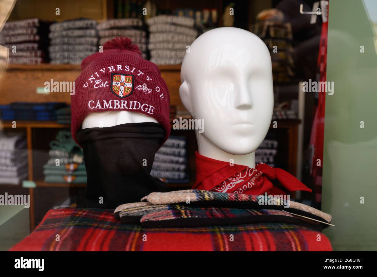 Two mannequin (dummy) heads in a shop window, one is wearing a beanie hat and mask, the other is not. Stock Photo