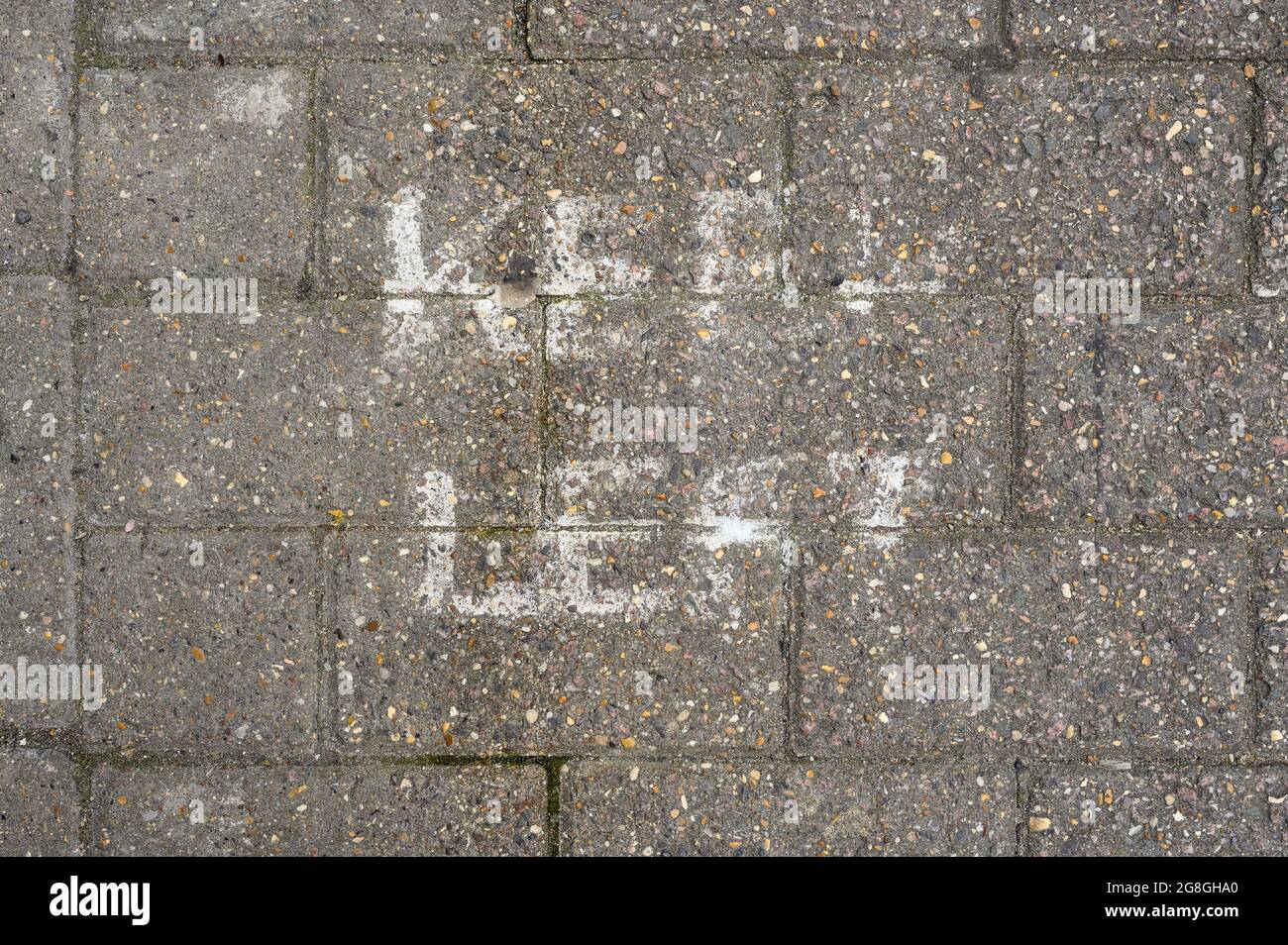 Faded Keep Left social distancing sign painted onto block paving. Stock Photo