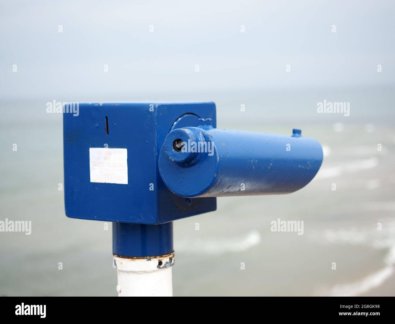 Close-up view of a coin operated telescope overlooking a sunny seaside beach Stock Photo