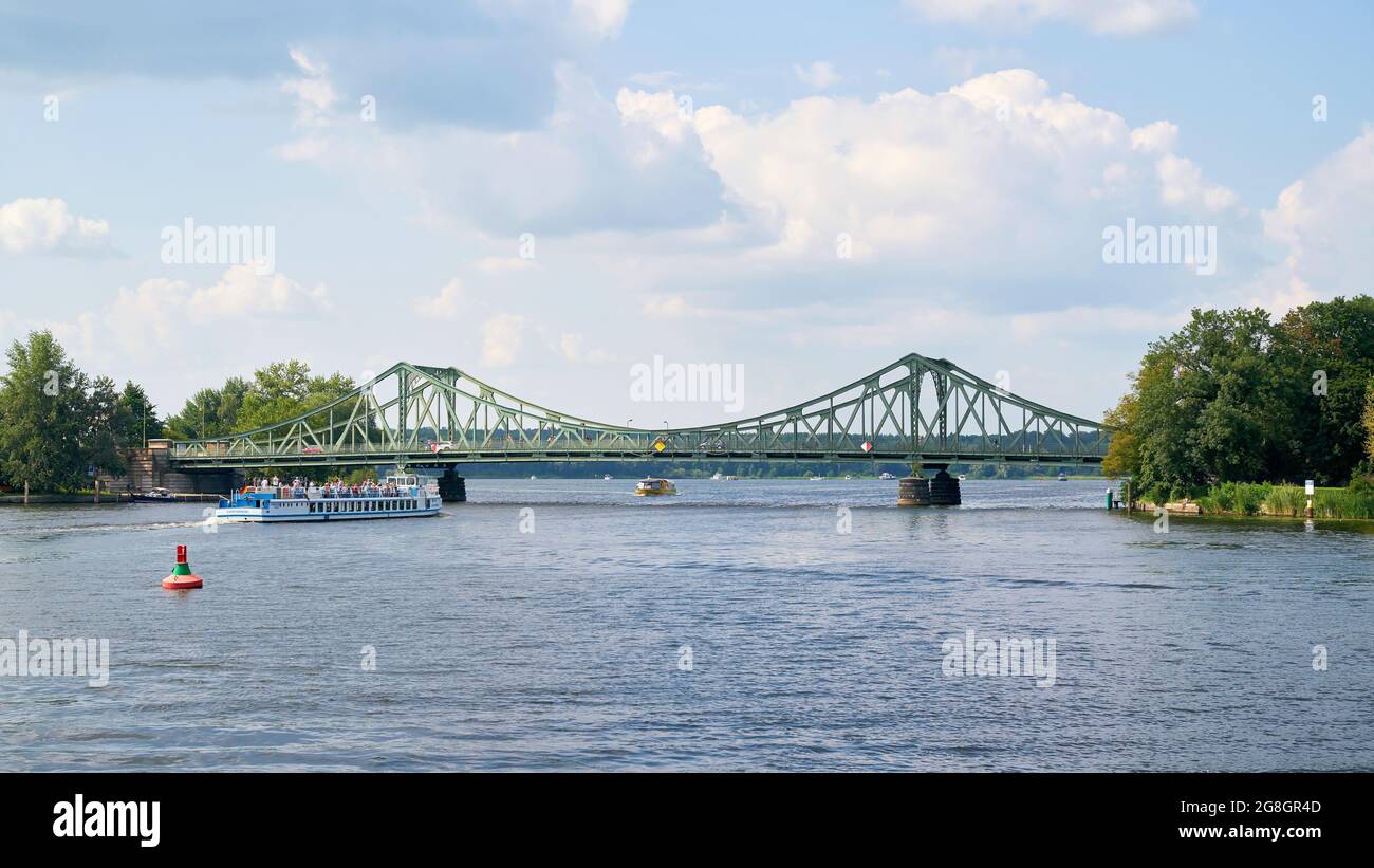The Glienicke Bridge over the Havel River between Potsdam and Berlin. In the foreground an excursion boat with tourists. Stock Photo
