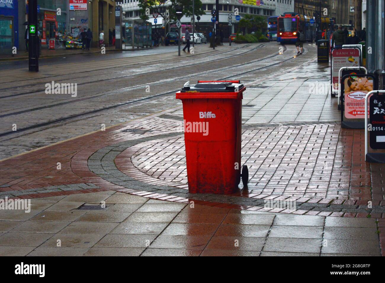 SHEFFIELD. SOUTH YORKSHIRE. ENGLAND. 07-10-21. High Street, waste bin on the pavement. The pavement is wet from a recent rain shower. Stock Photo