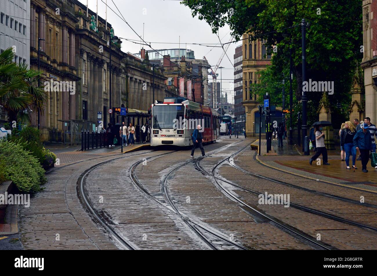 SHEFFIELD. SOUTH YORKSHIRE. ENGLAND. 07-10-21. High Street, the Cathedral tramstop  in the city centre. The cobbles are wet from a recent rain shower. Stock Photo