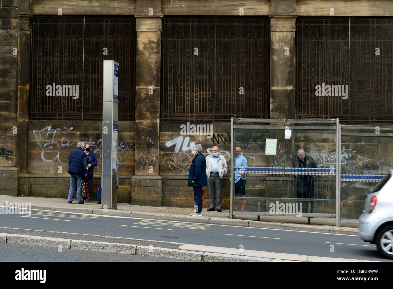 SHEFFIELD. SOUTH YORKSHIRE. ENGLAND. 07-10-21. Waingate, people waiting at a bus stop. Stock Photo