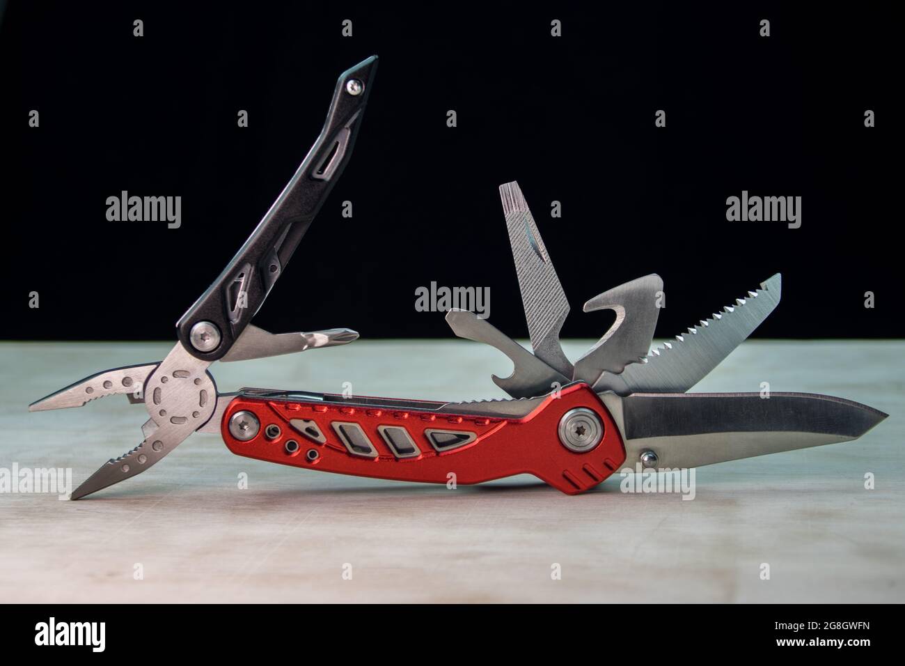 Beautifil red-black Multitool on white surface Black background Stock Photo