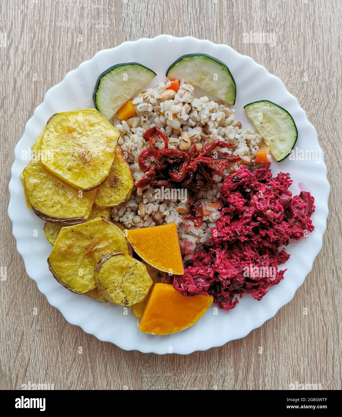 Pearl barley with soybeans, carrots, dried tomatoes. Baked potatoes, pumpkin and zucchini. Salad with beetroot Stock Photo