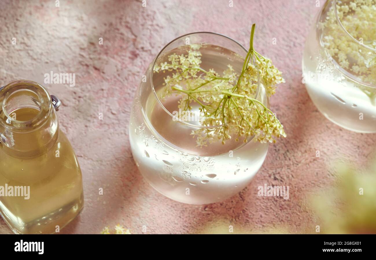 green alcohol drink in glass near fresh and organic limes on pink Stock  Photo by LightFieldStudios