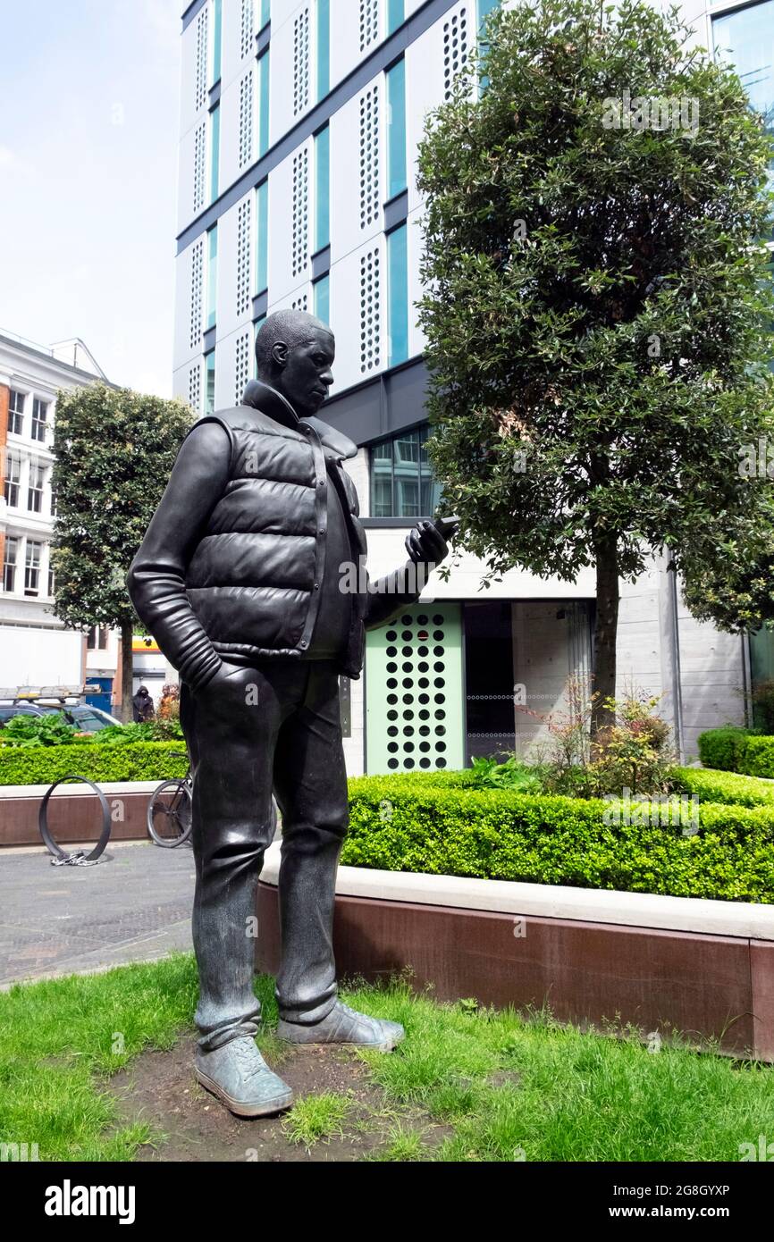 Sculptor Thomas J. Price statue of black man looking at mobile phone in White Collar Factory garden in Old Street Yard  London E1 UK  KATHY DEWITT Stock Photo
