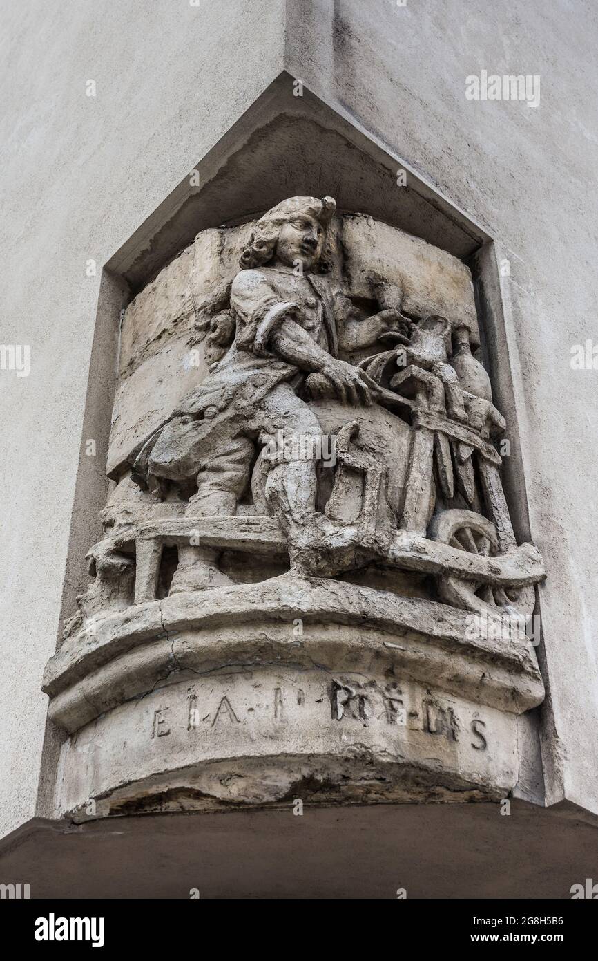 Old stone sculpture on Parisian street corner depicting a potter and potter's wheel - Paris, France. Stock Photo