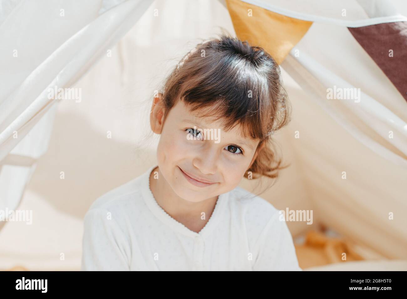 cute girl playing in teepee at home Stock Photo - Alamy