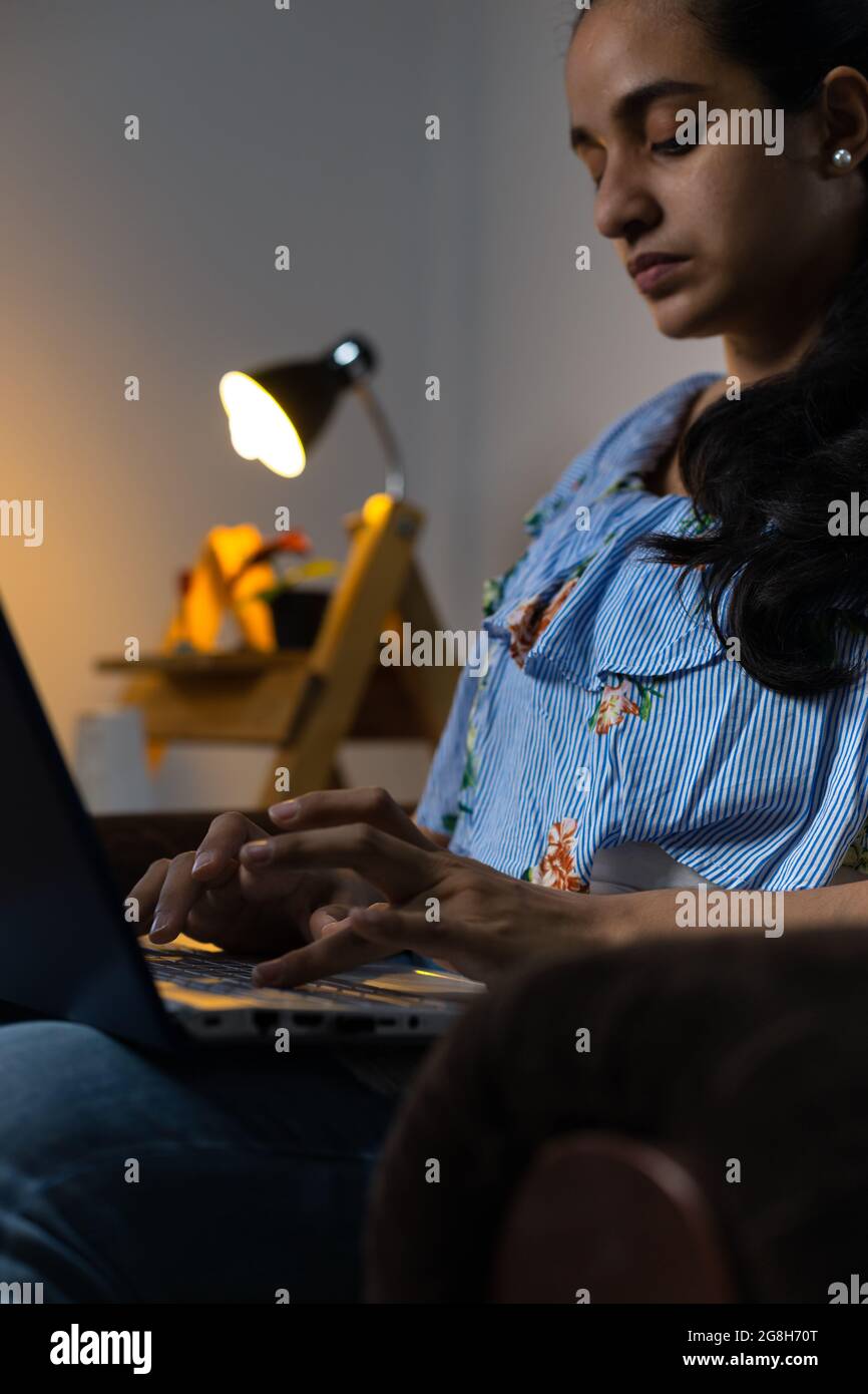 Pretty young Hispanic female typing on the computer from her living ...