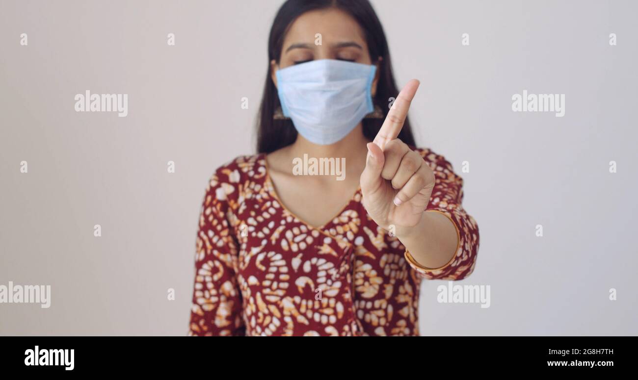 Denial Mask Example Young Indian female wearing a face mask showing a denial gesture Stock ...
