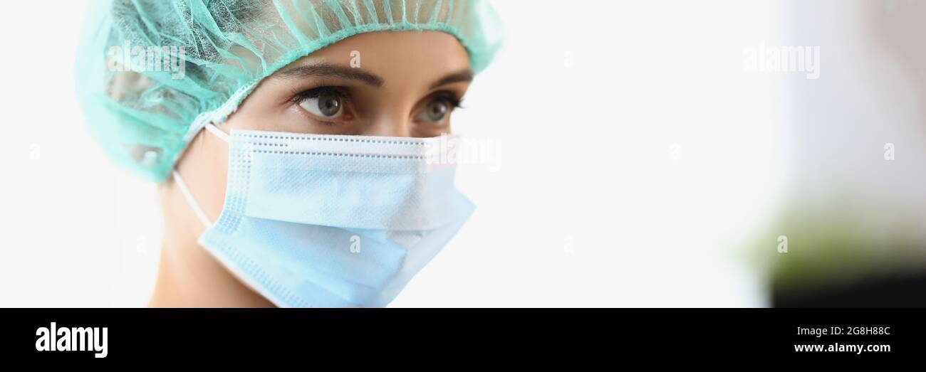 The female doctor wears a protective mask and cap Stock Photo Alamy