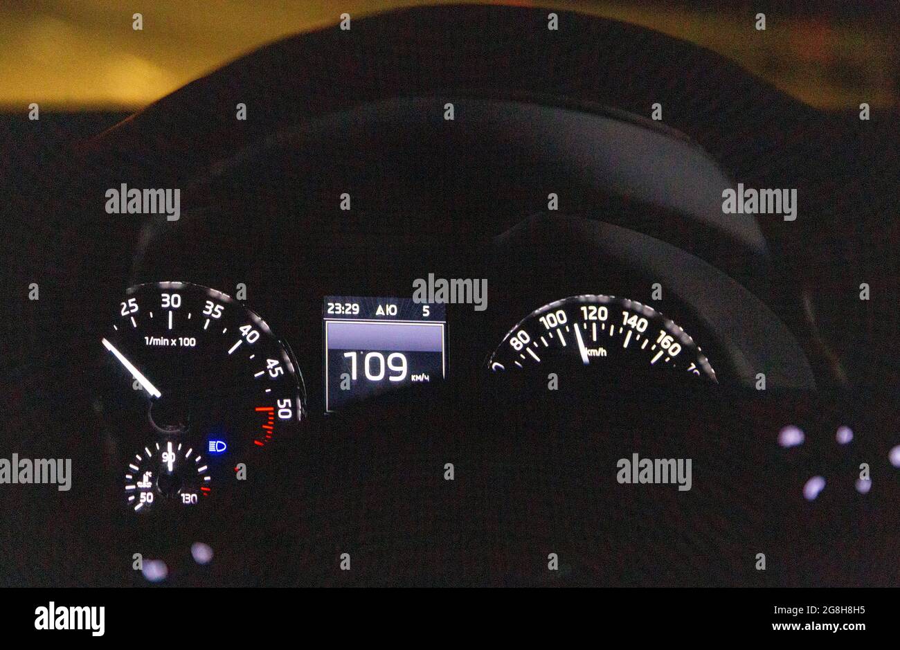 A modern car with illumination of the dashboard close-up, moving at a speed of 109 km. Photo taken through the steering wheel Stock Photo
