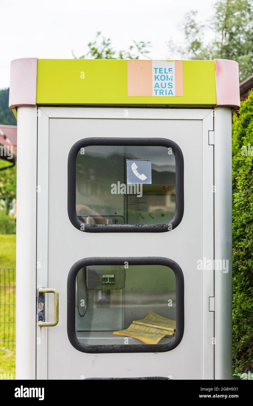 Flachau / Austria- Jule 30 2021: Gray and yellow telephone booth Austria Telekom with a telephone book visible inside Stock Photo