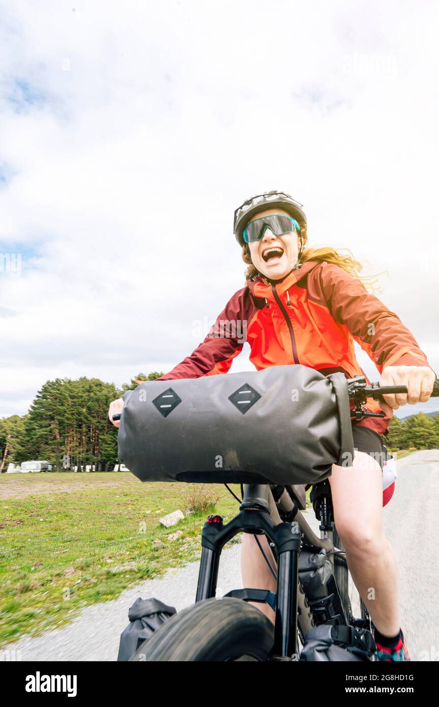 Woman enjoying with a mountain bike in nature, practices bikepacking Stock Photo