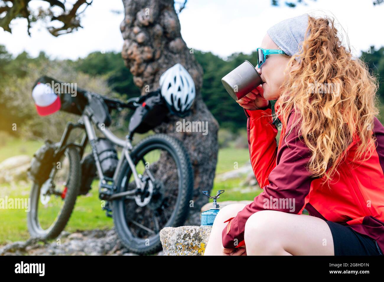 Woman enjoying with a mountain bike in nature, practices bikepacking Stock Photo