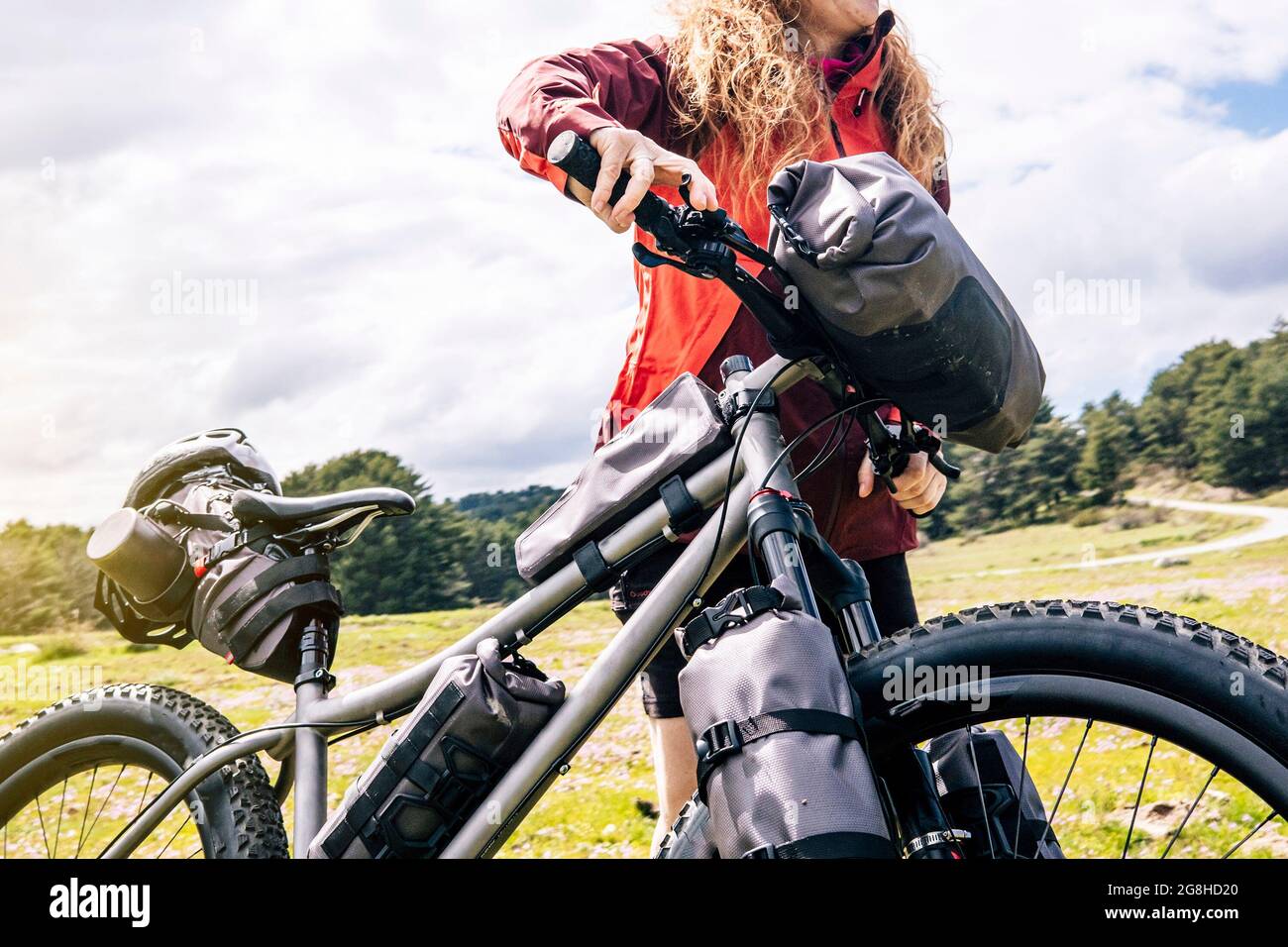 Woman enjoying with a mountain bike in nature, practices bikepacking Stock Photo