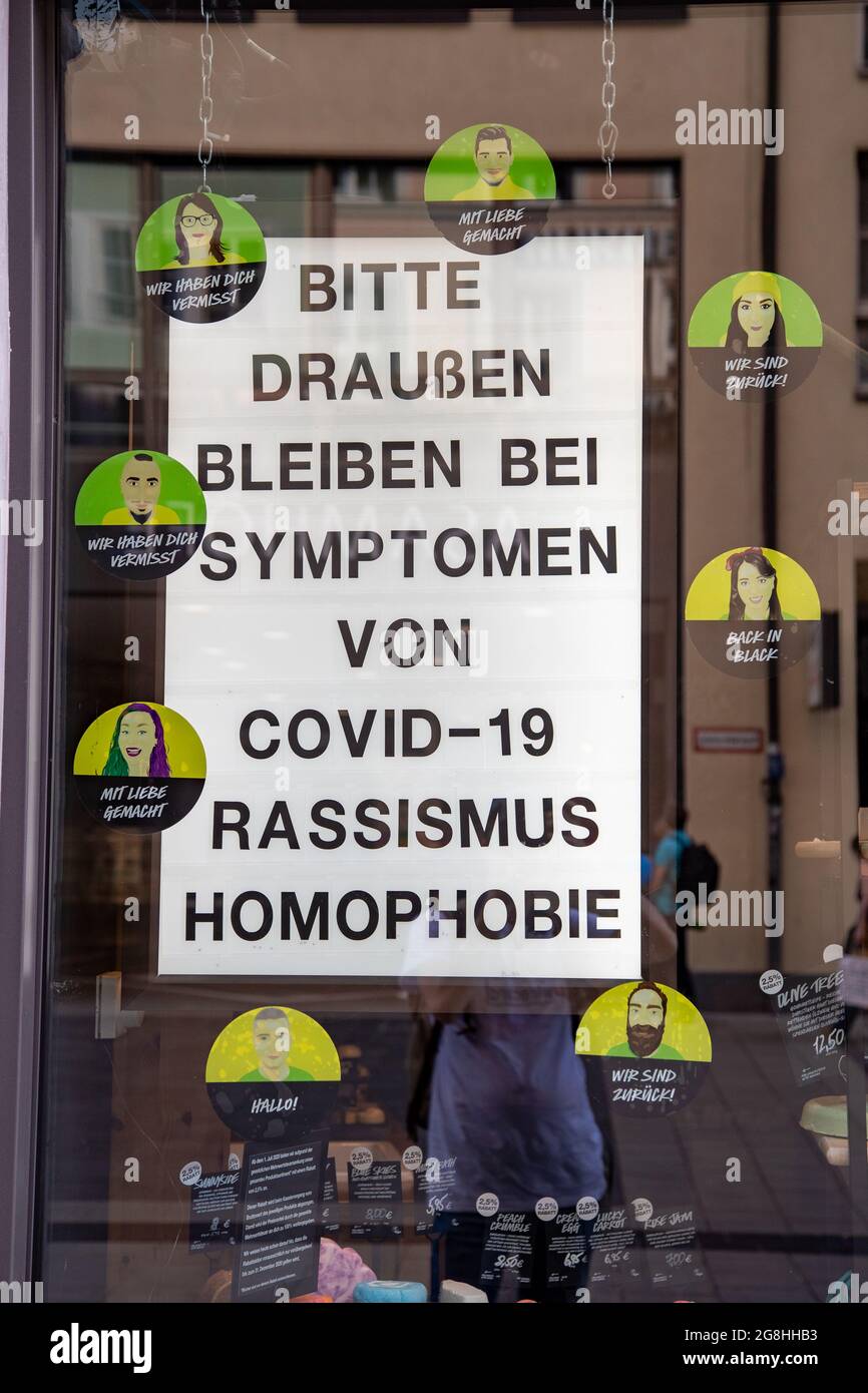 Schild an einem Schaufenster: " Bitte draußen bleiben bei Symptomen von Covid-19 Rassismus Homophobie " und wir sind zurück Aufklebern. Am Sonntag Abend, den 19. Juli 2020 sind Menschen die Fußgängerzone in der Sendlinger Straße entlang spaziert. In einigen Läden gab es Hinweise auf das Corona Virus. -- People enjoy a sunny sunday evening in Munich on July 19th 2020. (Photo by Alexander Pohl/Sipa USA) Credit: Sipa USA/Alamy Live News Stock Photo