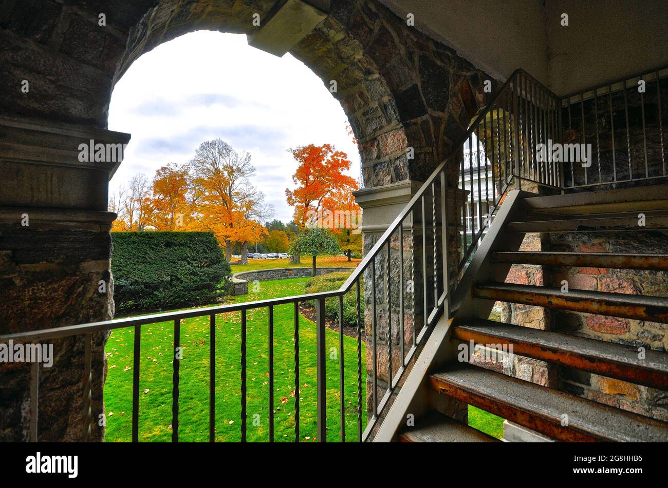 View of outdoor autumn leaf colour through the arch of the building Stock Photo